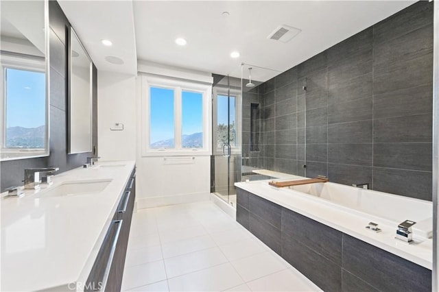 bathroom with a healthy amount of sunlight, separate shower and tub, vanity, and tile patterned floors