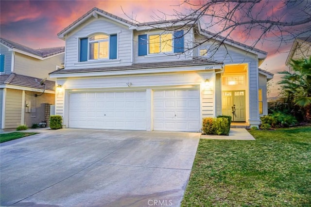 front facade with a garage and a yard