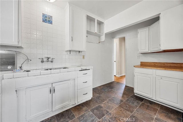 kitchen with sink, backsplash, and white cabinetry