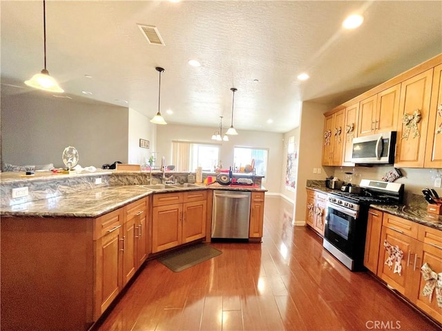 kitchen featuring sink, an inviting chandelier, appliances with stainless steel finishes, and hanging light fixtures