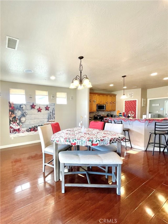 dining area with a textured ceiling and an inviting chandelier