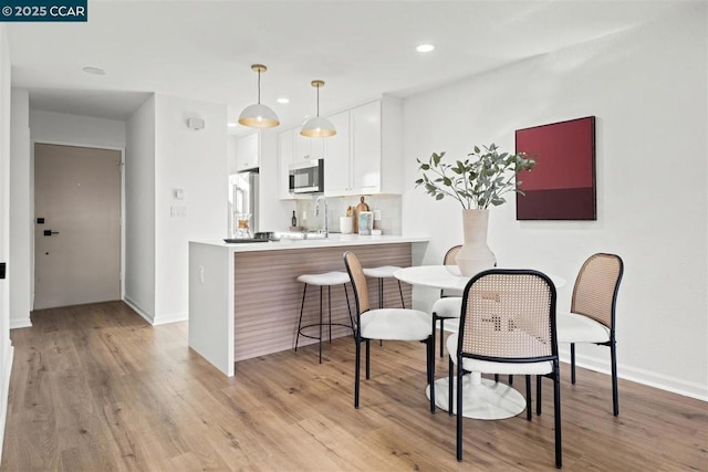 dining room featuring light wood-type flooring and sink