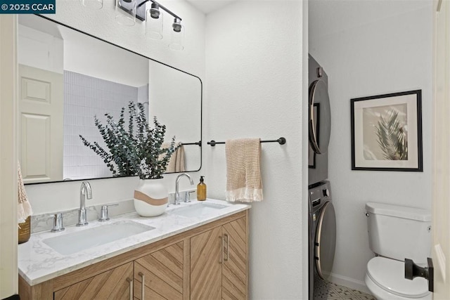 bathroom with stacked washer / drying machine, vanity, and toilet