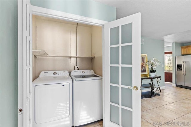 washroom featuring washing machine and clothes dryer and light tile patterned floors