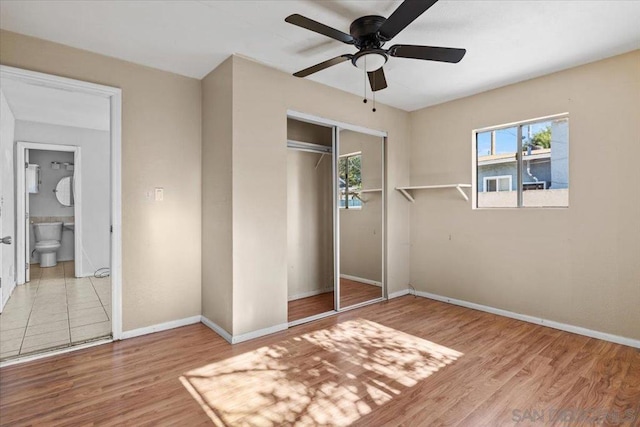 unfurnished bedroom with connected bathroom, a closet, ceiling fan, and light wood-type flooring