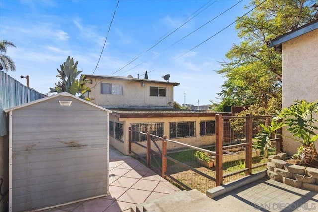 rear view of property with a storage shed