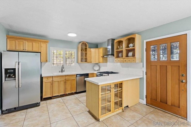 kitchen with kitchen peninsula, wall chimney range hood, backsplash, appliances with stainless steel finishes, and sink