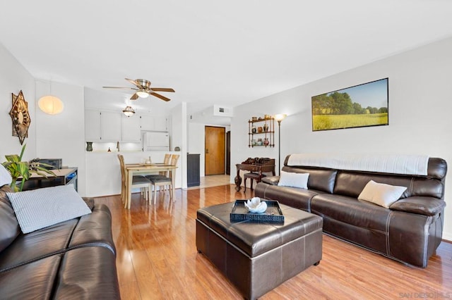 living room featuring ceiling fan and light hardwood / wood-style flooring