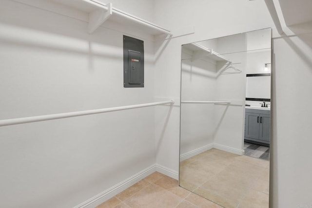 walk in closet featuring electric panel and light tile patterned flooring