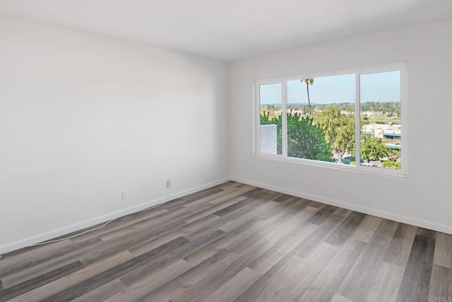 unfurnished room featuring baseboards and wood finished floors