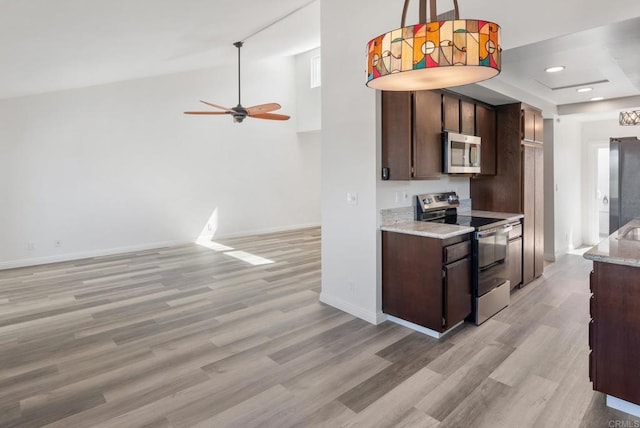 kitchen with light wood-style floors, baseboards, stainless steel appliances, and dark brown cabinets