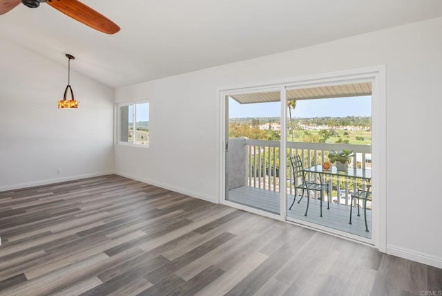 unfurnished room with a ceiling fan, lofted ceiling, baseboards, and wood finished floors