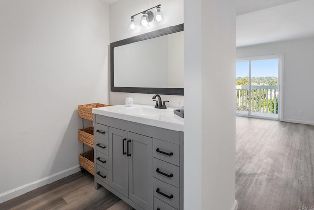 bathroom featuring wood finished floors, vanity, and baseboards