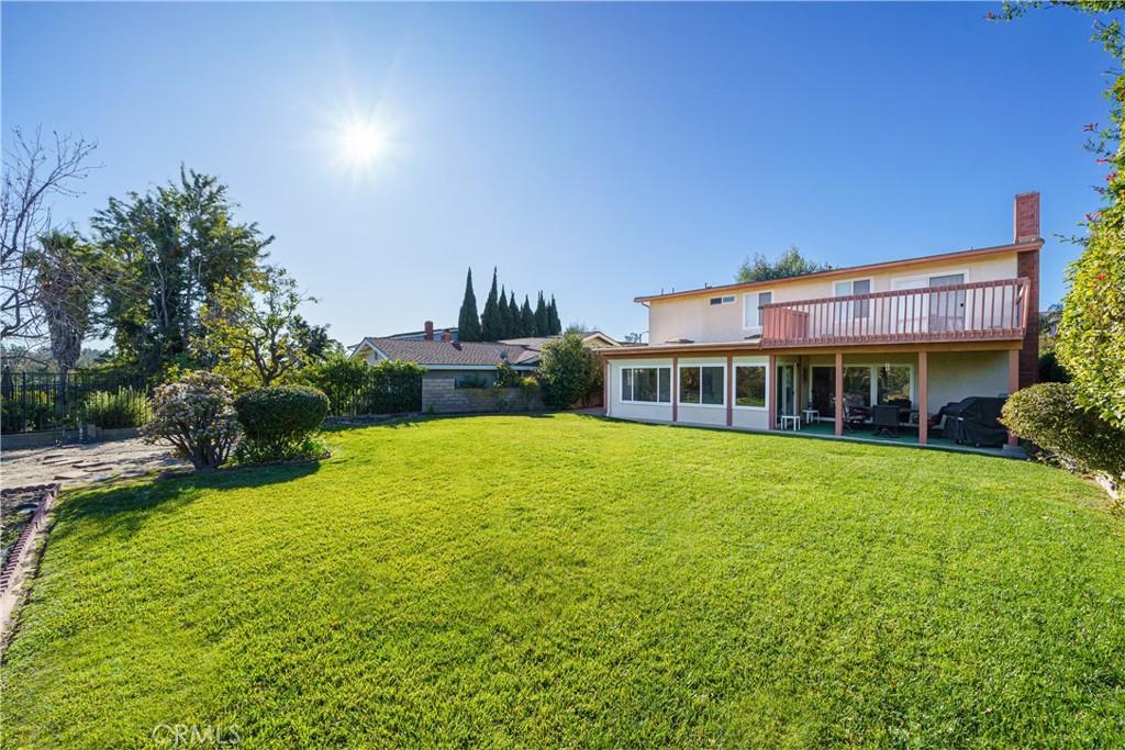 rear view of house featuring a lawn and a wooden deck