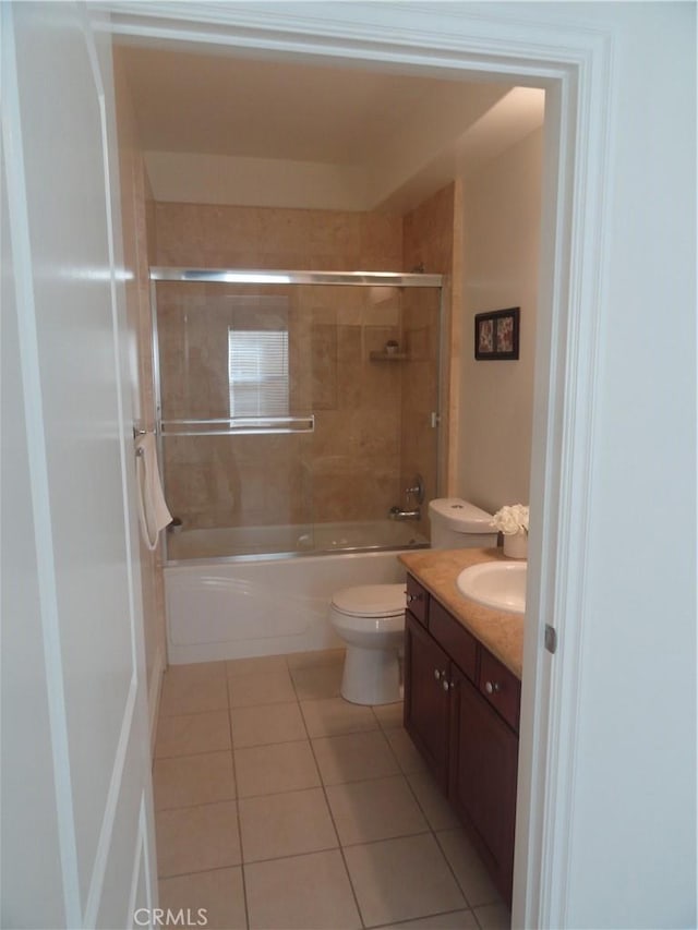 full bathroom featuring tiled shower / bath combo, tile patterned floors, vanity, and toilet