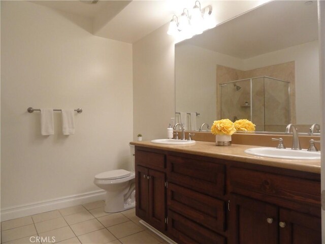 bathroom featuring vanity, a shower with shower door, toilet, and tile patterned flooring