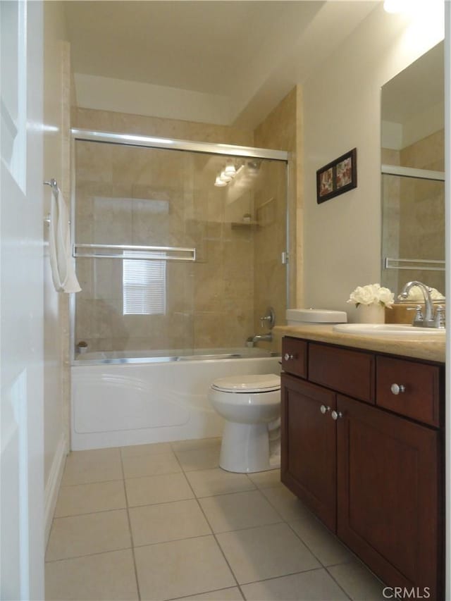 full bathroom with combined bath / shower with glass door, toilet, tile patterned flooring, and vanity