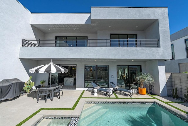 rear view of house featuring a balcony and a patio