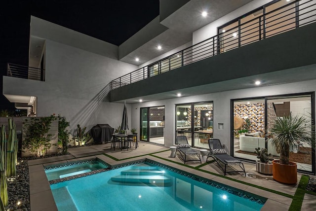 pool at twilight with an in ground hot tub