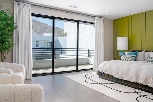 bedroom featuring a mountain view, access to exterior, and hardwood / wood-style floors