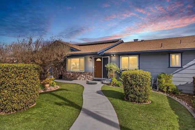 ranch-style home featuring a lawn