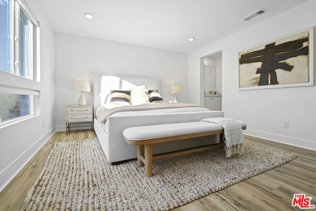 bedroom featuring light hardwood / wood-style floors and ensuite bathroom