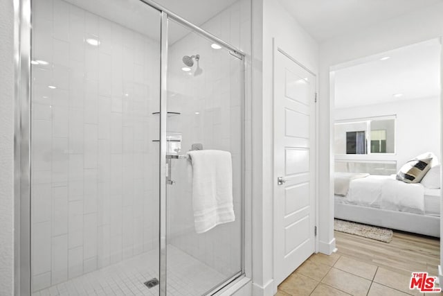 bathroom featuring tile patterned flooring and a shower with shower door