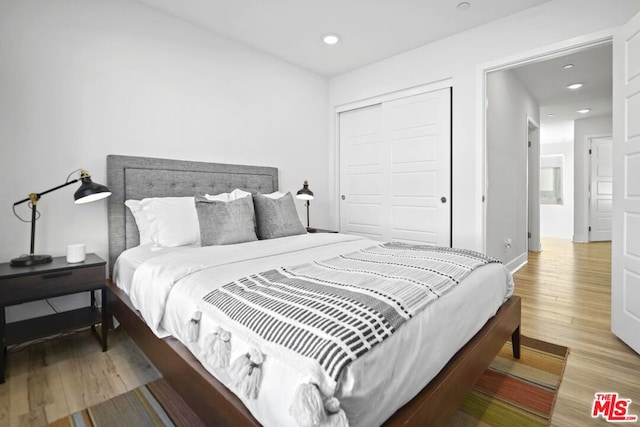 bedroom with a closet and hardwood / wood-style floors