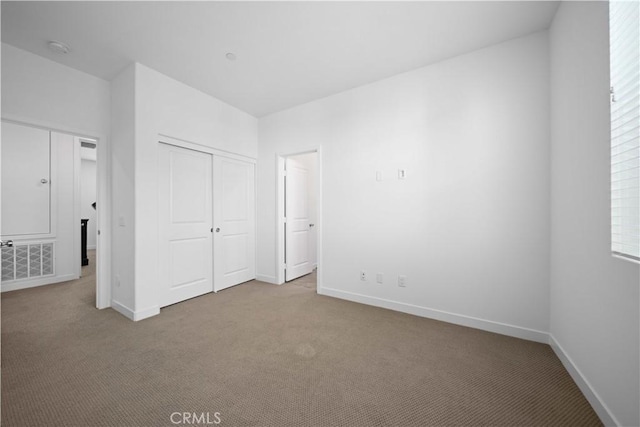 unfurnished bedroom with a closet and light carpet