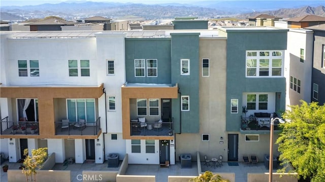 view of property featuring central air condition unit and a mountain view