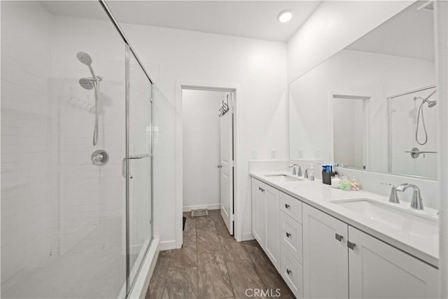 bathroom featuring hardwood / wood-style floors, an enclosed shower, and vanity