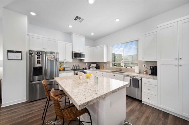 27014 Hummingbird Ln, Valencia, CA 91381 - kitchen with a sink, backsplash, appliances with stainless steel finishes, visible vents, and white cabinets