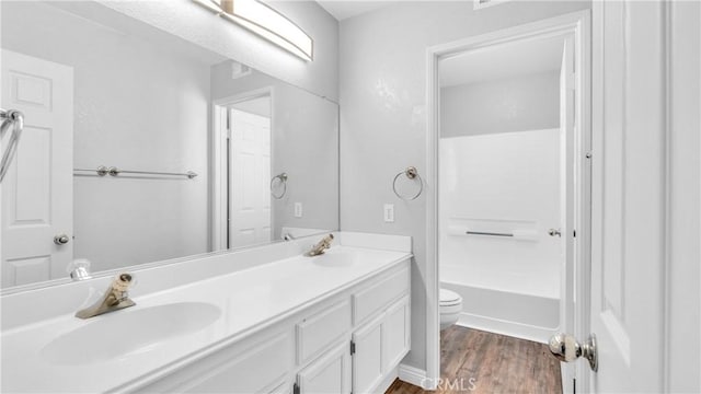 full bathroom featuring washtub / shower combination, toilet, vanity, and hardwood / wood-style flooring