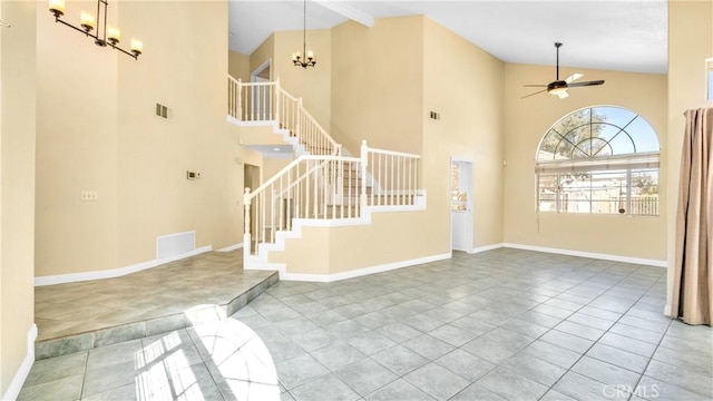 tiled foyer featuring ceiling fan with notable chandelier and high vaulted ceiling