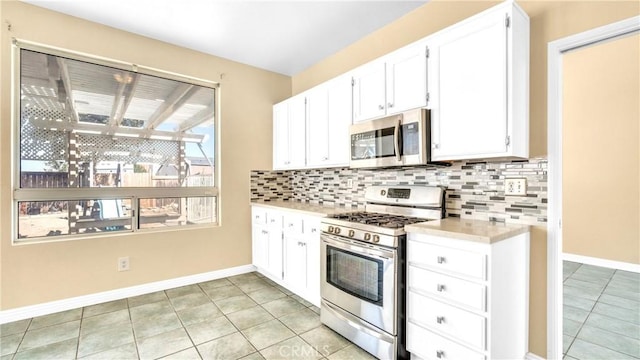 kitchen featuring stainless steel appliances, white cabinetry, tasteful backsplash, and light tile patterned floors