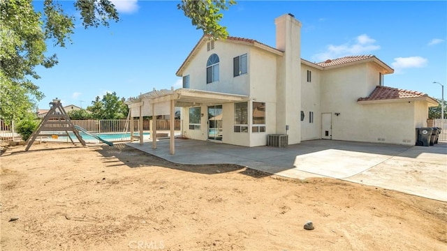 rear view of house with a patio area, central AC, and a pergola