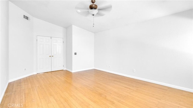 empty room with ceiling fan, vaulted ceiling, and light wood-type flooring