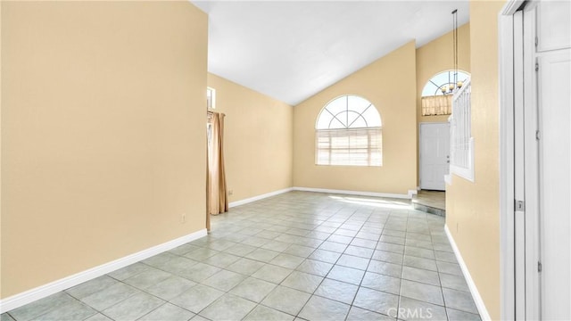 empty room with light tile patterned flooring and vaulted ceiling