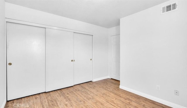 unfurnished bedroom featuring a closet and light hardwood / wood-style flooring