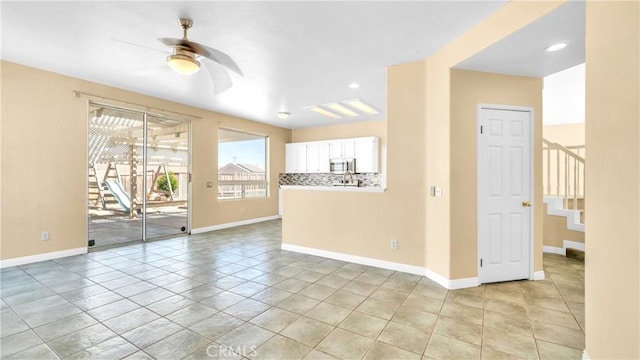 unfurnished room with ceiling fan and light tile patterned floors