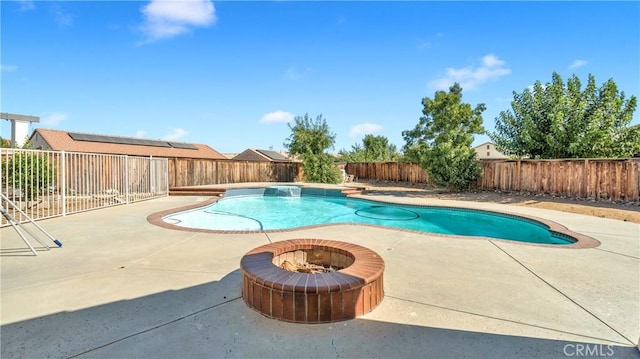 view of swimming pool featuring an outdoor fire pit and a patio