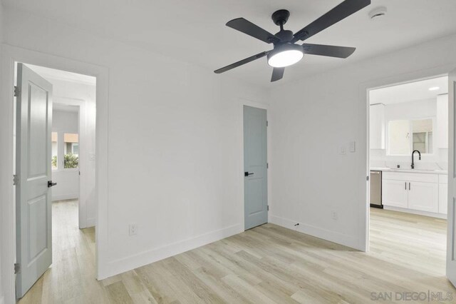 unfurnished bedroom featuring ensuite bath, ceiling fan, light hardwood / wood-style floors, and sink