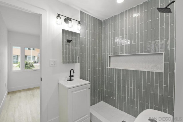 bathroom featuring sink, tiled shower, and hardwood / wood-style floors