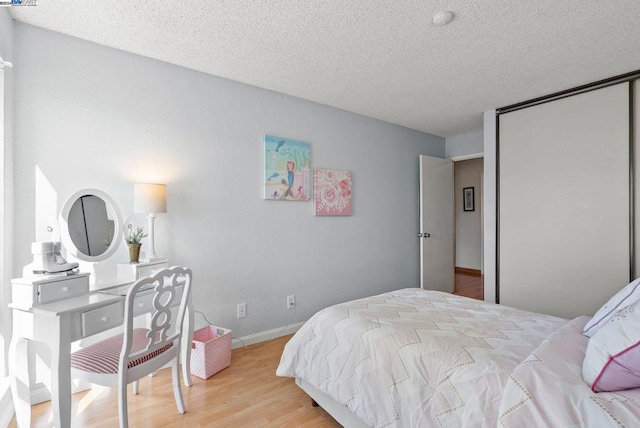 bedroom featuring a textured ceiling and light hardwood / wood-style floors