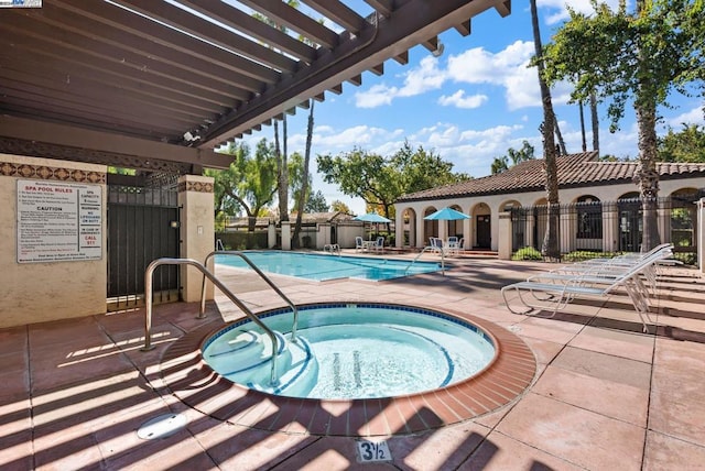 view of swimming pool with a community hot tub, a pergola, and a patio