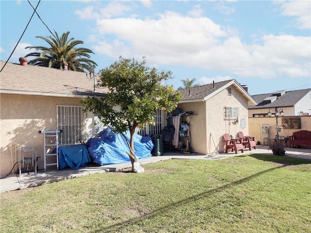 back of house with a yard and a patio