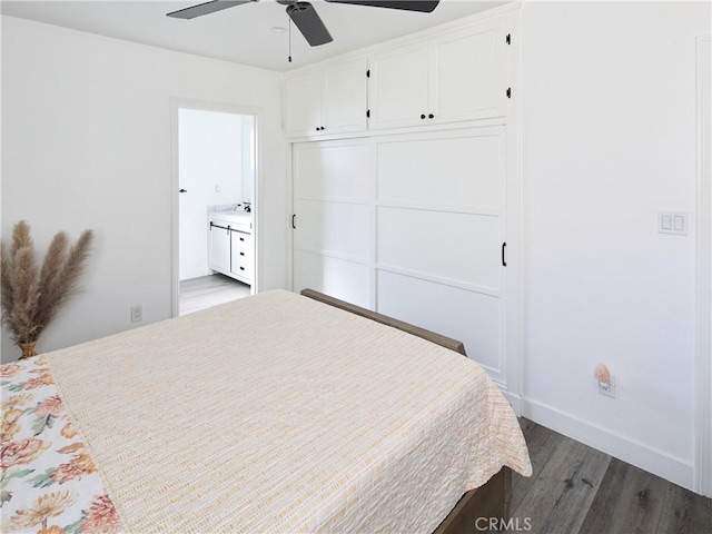 bedroom featuring ceiling fan, dark hardwood / wood-style flooring, ensuite bathroom, and a closet