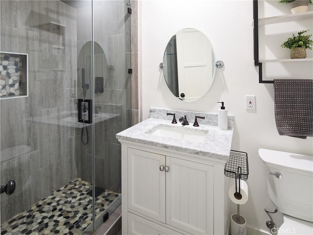 bathroom featuring vanity, walk in shower, and toilet