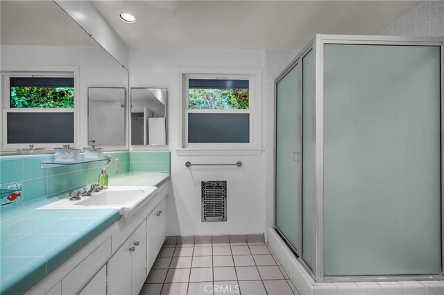 bathroom with an enclosed shower, backsplash, tile patterned flooring, and vanity