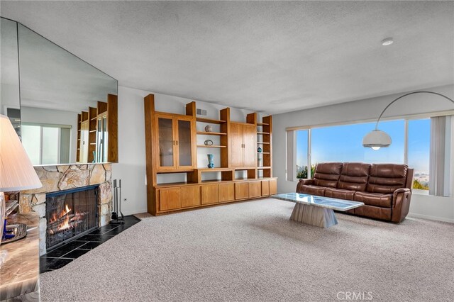 carpeted living room featuring a fireplace and a textured ceiling